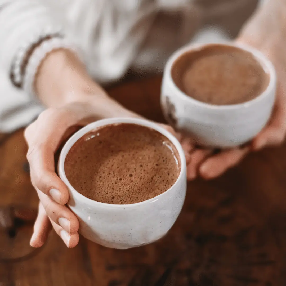 Frau hält zwei Tassen Criollo Blanco Kakao von Naturu